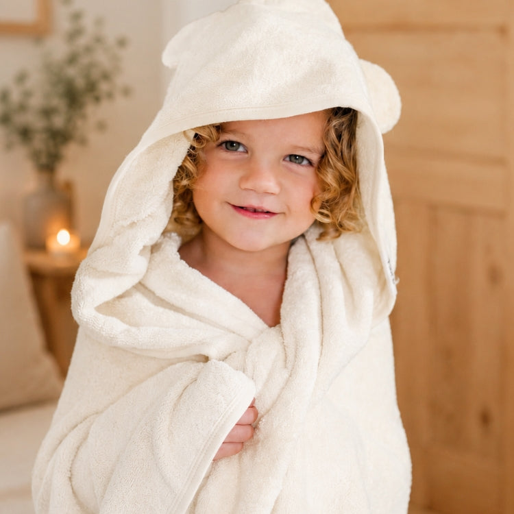 Older child wearing the Ivory Kiin hooded towel